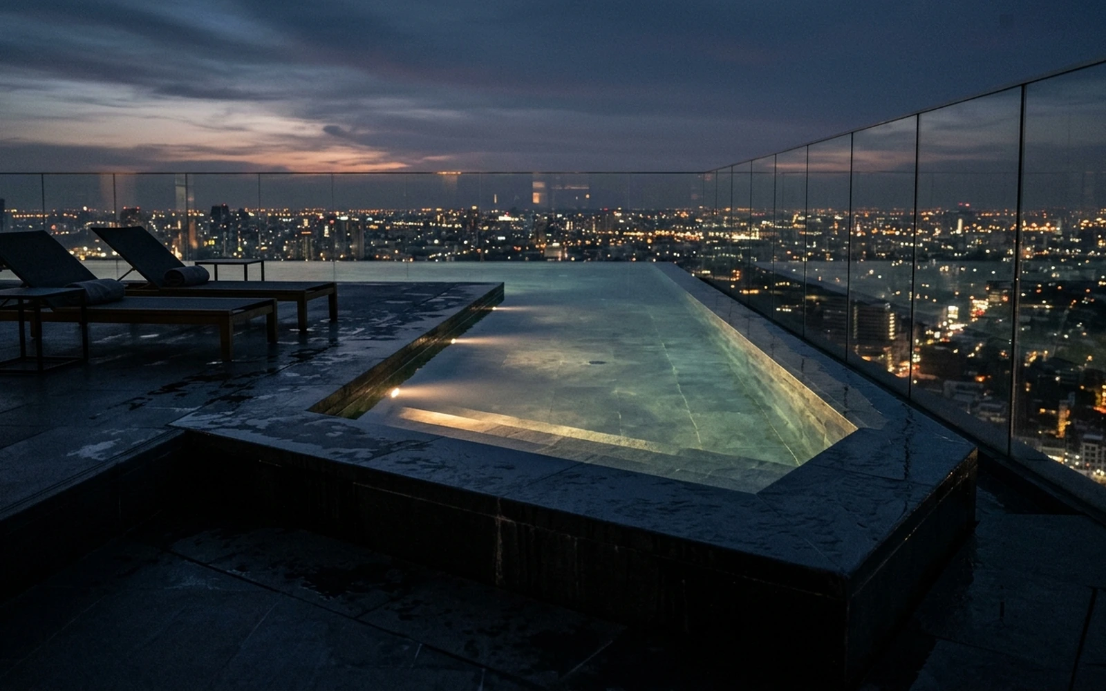 Alberca infinity en azotea de torre residencial con vista panorámica a la ciudad