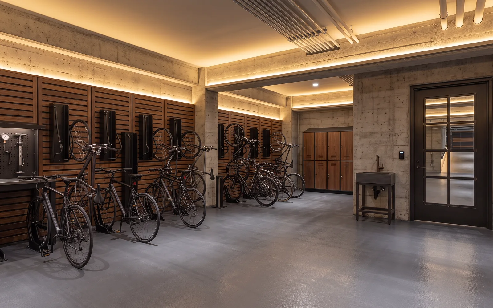 Ciclopuerto residencial interior con racks de diseño en acero negro y muro de madera
