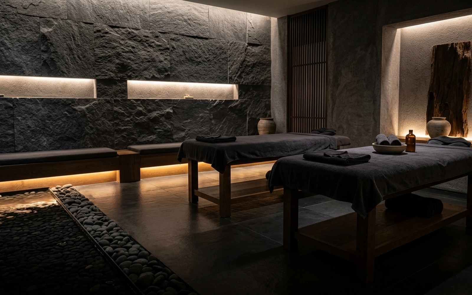 Spa de bienestar residencial con acabados de piedra natural e iluminación ambiental cálida