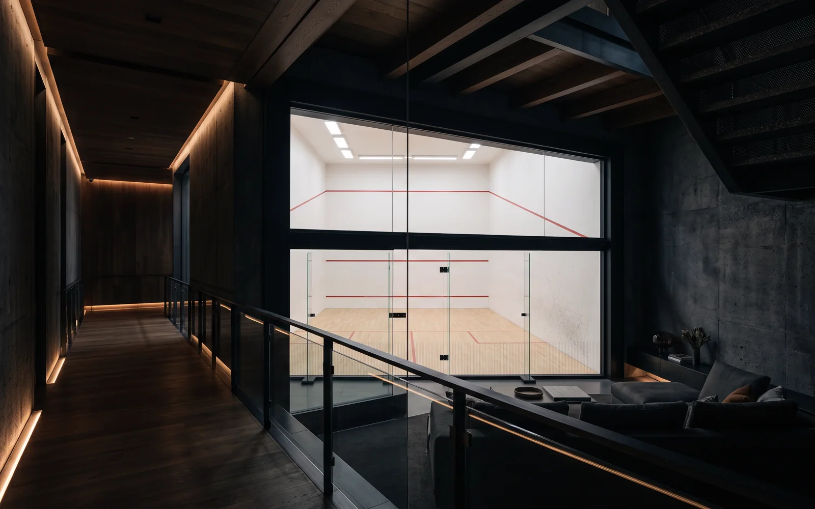 Cancha de squash con líneas rojas reglamentarias vista desde el pasillo superior